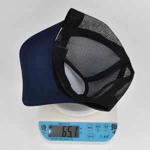 Dettaglio ravvicinato che mostra il peso di 65,1 g di un cappellino trucker in rete blu su bilancia