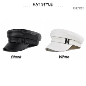 Dettaglio di cappelli da marinaio in pelle bianchi e neri con logo M in metallo