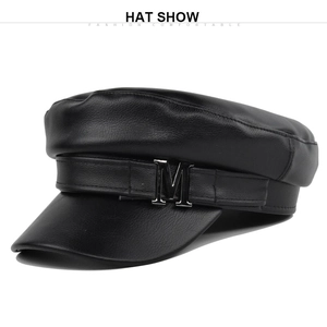 Dettaglio del cappello in pelle PU nera con logo M in metallo e trama in pelle definita