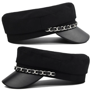 Dettaglio cappello newsboy nero con tessuto strutturato e catena in metallo argento