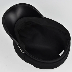 Dettaglio del cappello da marinaio nero con visiera in pelle, catena e etichetta interna