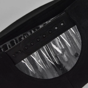 Close-up of the adjustable plastic snapback strap and black cotton fabric of the cap