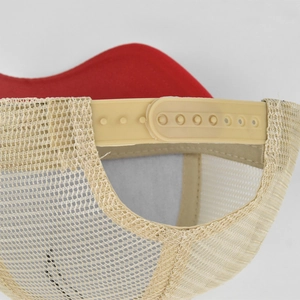 Detailed view of the red mesh trucker hat featuring an adjustable plastic snapback closure