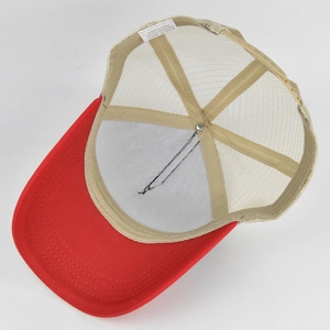 Detail view of red and beige mesh trucker hat showing internal stitching and fabric label