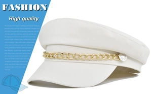 Detail of white faux leather baker boy hat with gold chain and metal side buttons
