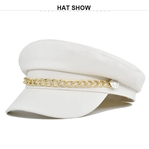 Detail of white newsboy cap with gold chain and smooth faux leather texture