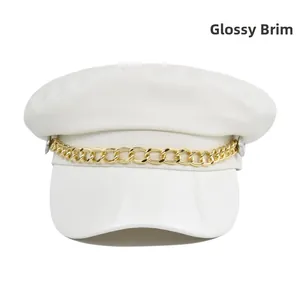 Detail of white baker boy hat featuring a glossy patent leather brim and gold chain link