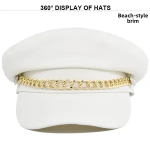 Detail view of white newsboy hat with golden metal chain and glossy wide brim surface