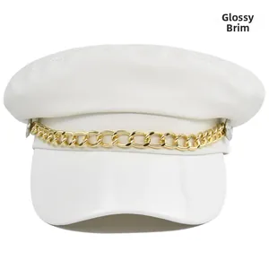 Detail of white leather baker boy hat showing the glossy brim and gold metal chain link