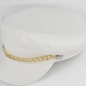 Detail shot of a white PU leather baker boy hat with a stylish chunky gold chain decoration
