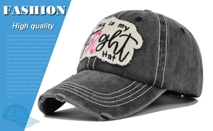 Detail of embroidered 'Fight Hat' patch and pink ribbon on distressed grey baseball cap