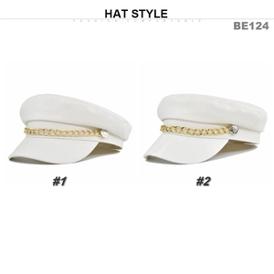 Detail view of two white PU leather navy caps featuring gold metal chain and rhinestone studs