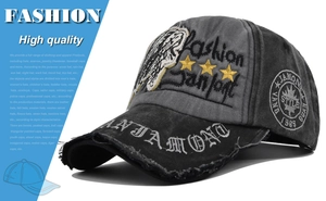 Detail of vintage washed baseball cap featuring skull embroidery and distressed brim details
