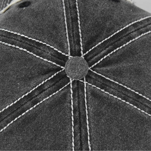 Detail of gray washed cotton baseball cap showing contrast stitching and six-panel crown