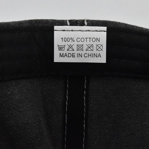 Close-up of the white cotton washing label inside the black vintage embroidered baseball cap