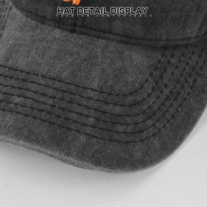 Detailed close-up of stitching and washed cotton texture on the grey baseball cap brim