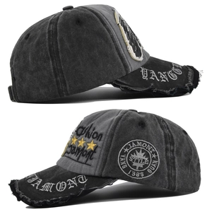 Detailed close-up showing skull embroidery and distressed washed texture on vintage grey cap