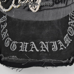 Detailed close-up of vintage washed baseball cap with skull embroidery and frayed edges