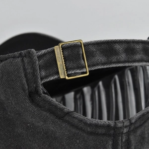 Detail of adjustable bronze metal buckle and washed distressed fabric on baseball cap