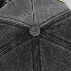 Close-up of vintage washed denim baseball cap top with detailed stitching and button