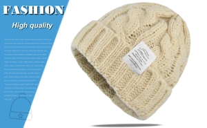 Detailed view of beige cable-knit beanie featuring a custom sewn-on fashion fabric label