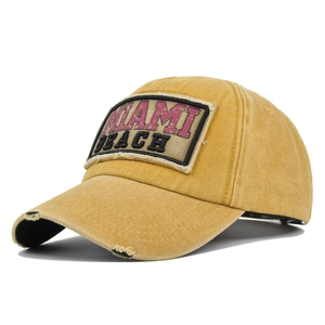 Detail van vintage gewassen mosterdgele honkbalpet met Miami Beach patch en versleten rand