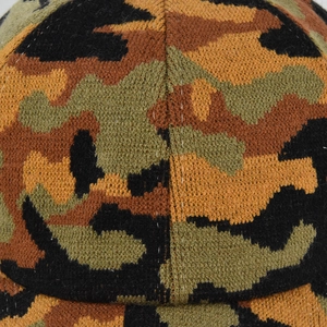Close-up of knit ponytail hat featuring a camo pattern in black, green, and orange yarn
