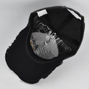 Detail view of vintage cotton baseball cap showing frayed brim and metal buckle