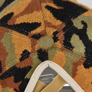 Macro shot of camouflage knit baseball cap top showing texture and button detail