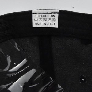 Close-up of the internal 100% cotton material tag and stitching on the black baseball cap