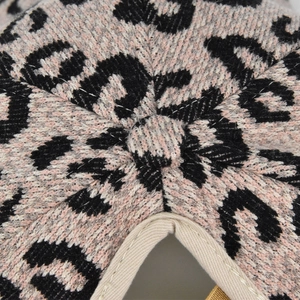 Gros plan sur la texture tricotée léopard et le bouton supérieur du chapeau d'hiver