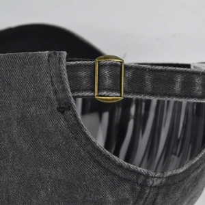 Detail van vintage gewassen denim honkbalpet met een verstelbare metalen schuifgesp