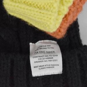 Detailed close-up of thick cable knit texture with fashion woven label and vibrant fibers