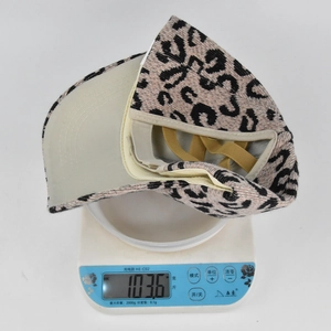 Vue détaillée du bonnet léopard pour queue de cheval pesant 103,6 g sur une balance