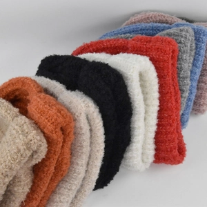 Detailopname van grove gebreide mutsen met textuur in beige, rood en diverse