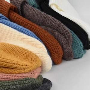 Dettaglio di berretti in maglia a coste impilati che mostra colori vivaci e trama tessile