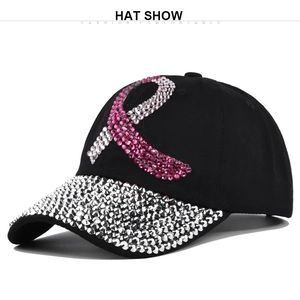 Detailed view of black baseball cap featuring pink rhinestone ribbon and sparkling brim