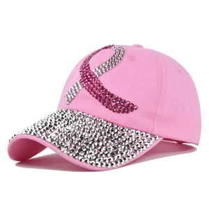 Detail of pink baseball cap featuring rhinestone breast cancer ribbon and studded brim