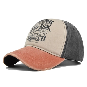 Detail of distressed brim and graffiti print on color-block vintage baseball cap