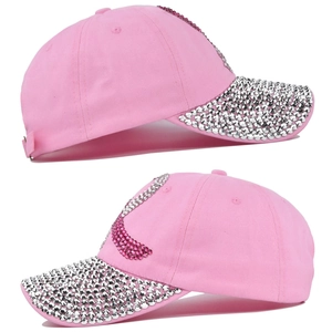 Detailed view of pink baseball cap with rhinestone logo and silver sequins on the brim