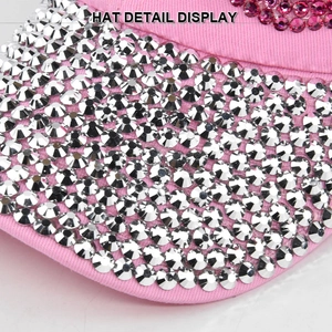 Detailed close-up of shiny rhinestones on pink canvas baseball cap brim and embroidery