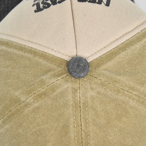 Detailed macro view of the two-tone cotton baseball cap crown with contrast stitching