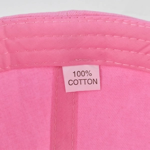 Close-up of 100% cotton fabric label and internal stitching on the pink baseball cap