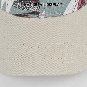 Detailopname van de versterkte stiksels op de klep van een honkbalpet met tropische print