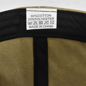 Detail view of khaki baseball cap inner seam with care label showing material composition