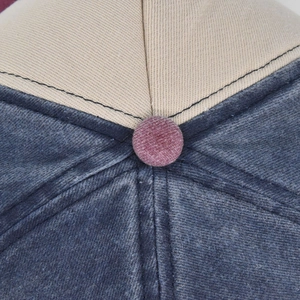 Makro-Detail der Baseballkappe mit Cord-Knopf und hochwertigen Kontrastnähten in Blau