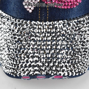 Detailed view of dark blue denim baseball cap featuring sparkling silver and pink rhinestones