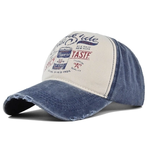 Detailed view of distressed baseball cap featuring vintage graffiti and washed denim