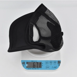 Gros plan d'une casquette filet noire sur une balance affichant un poids de 67,1 grammes