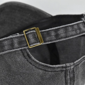 Detail of washed cotton baseball cap with adjustable bronze metal buckle and strap